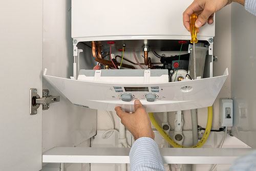 HVAC technician repairing an indoor boiler in Drexel Heights