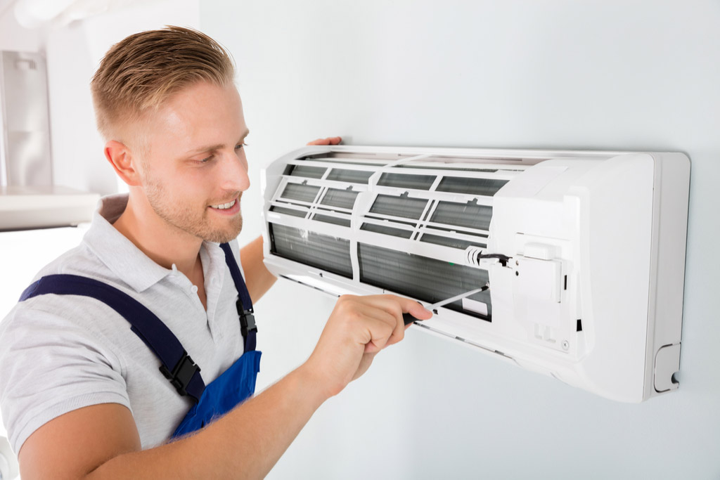 HVAC technician performing ductless air conditioning maintenance in Drexel Heights