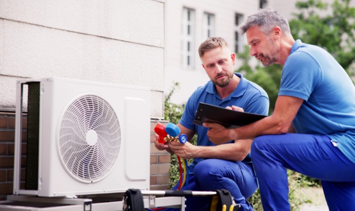 HVAC technicians installing an outdoor air conditioning unit in Drexel Heights