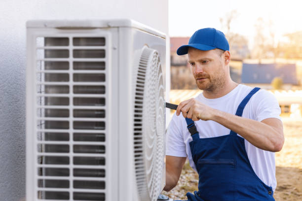 HVAC technician servicing an outdoor air conditioning unit in Drexel Heights