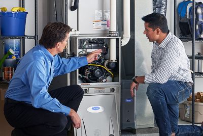 65df8c11f3e4c468cbd351a5_furnace repair vs replacement – Copy HVAC technician explaining furnace repair and maintenance to a homeowner in Drexel Heights, AZ