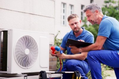 ac-installation-in-claremont-ca HVAC technicians reviewing an outdoor air conditioning unit in Drexel Heights, AZ