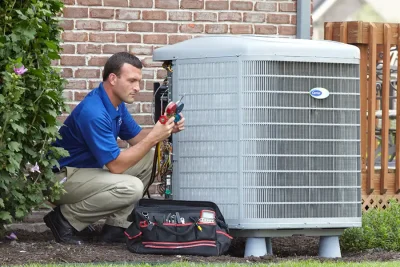 design-air-heating-and-air-conditioning-decatur-il-05 – Copy HVAC technician inspecting an outdoor air conditioning unit in Drexel Heights, AZ